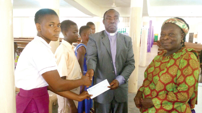 Rev. Sammy Aaron Amoako (2nd right), the HO East Synod Moderator, presenting a cheque to the students